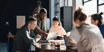 Team collaborating around a laptop